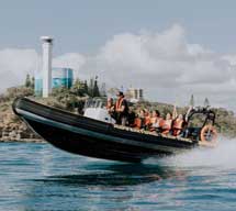 Wave riding in a speed raft in front of Point Cartwright
