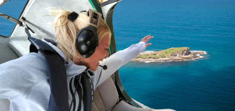 Woman flying with doors off in seaplane over Mudjimba Island